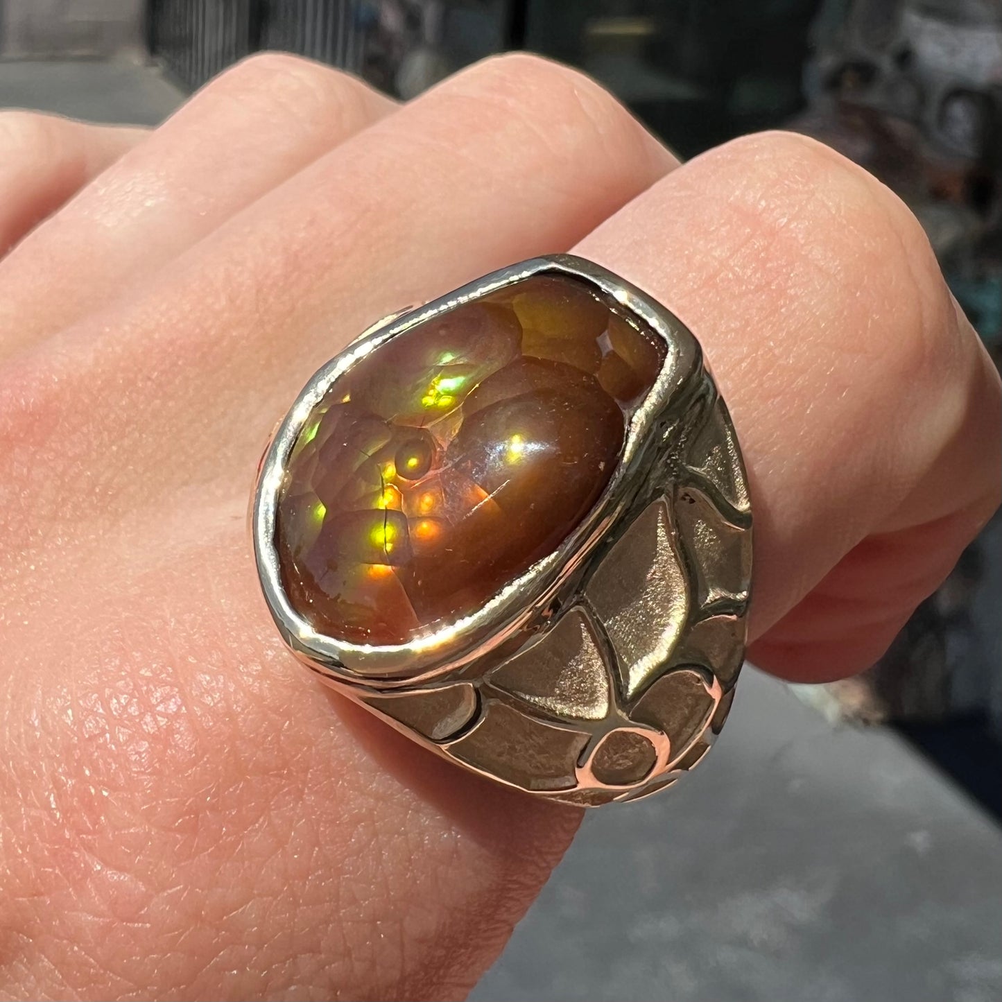 A men's heavy yellow gold ring mounted with a Mexican fire agate stone.  The shank of the ring is textured.