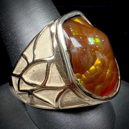 A men's heavy yellow gold ring mounted with a Mexican fire agate stone.  The shank of the ring is textured.