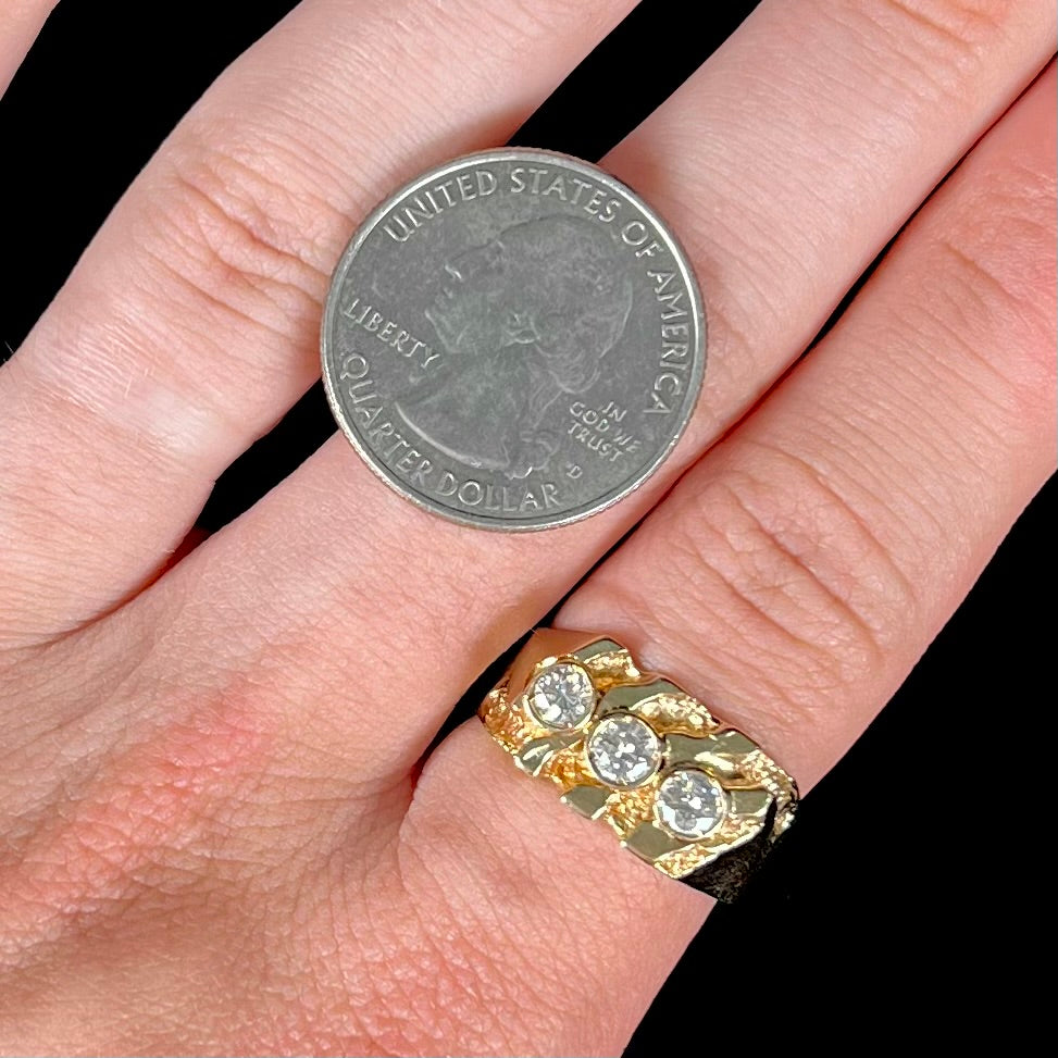 A men's yellow gold ring set with three round brilliant cut diamonds.  There are scratches along the shank.