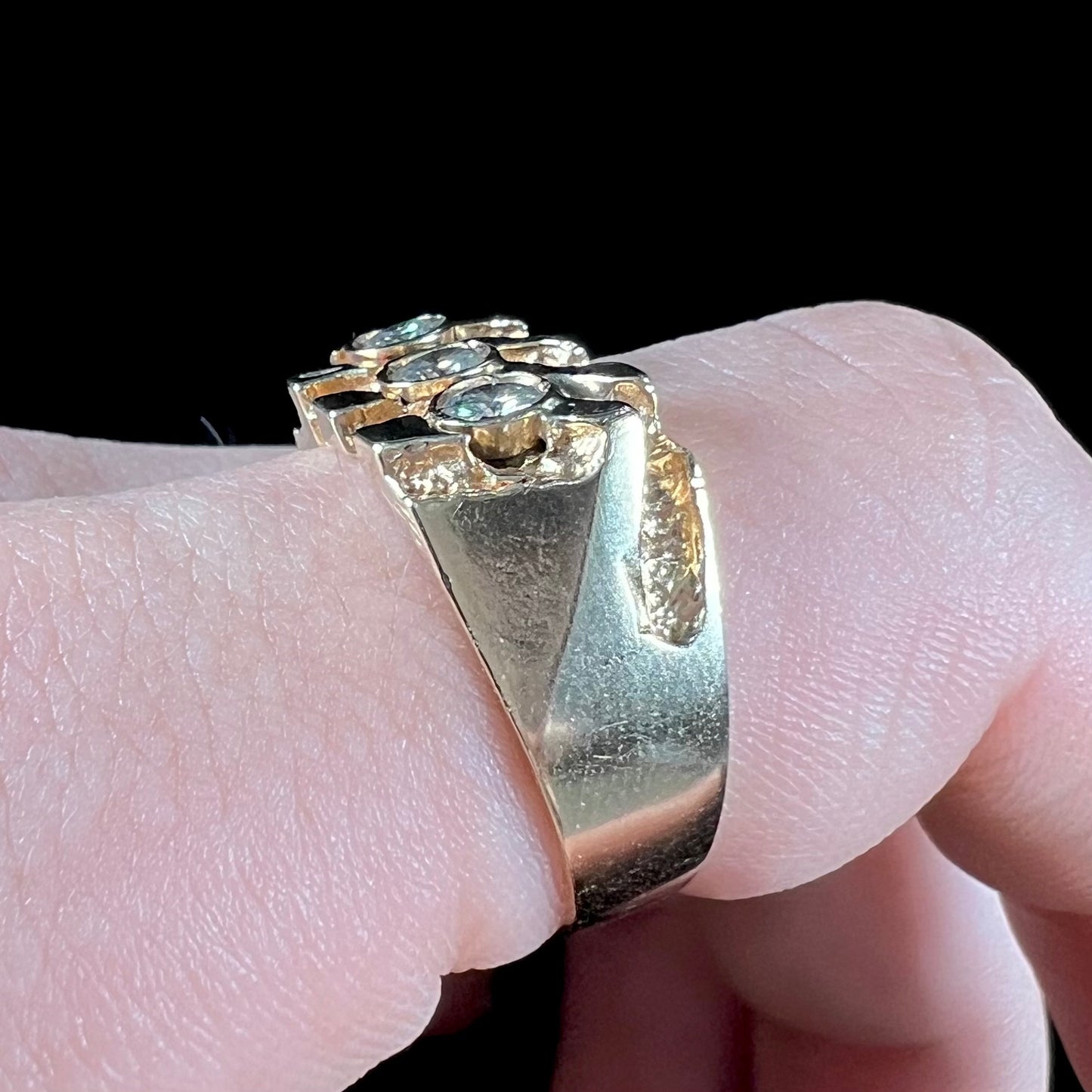 A men's yellow gold ring set with three round brilliant cut diamonds.  There are scratches along the shank.