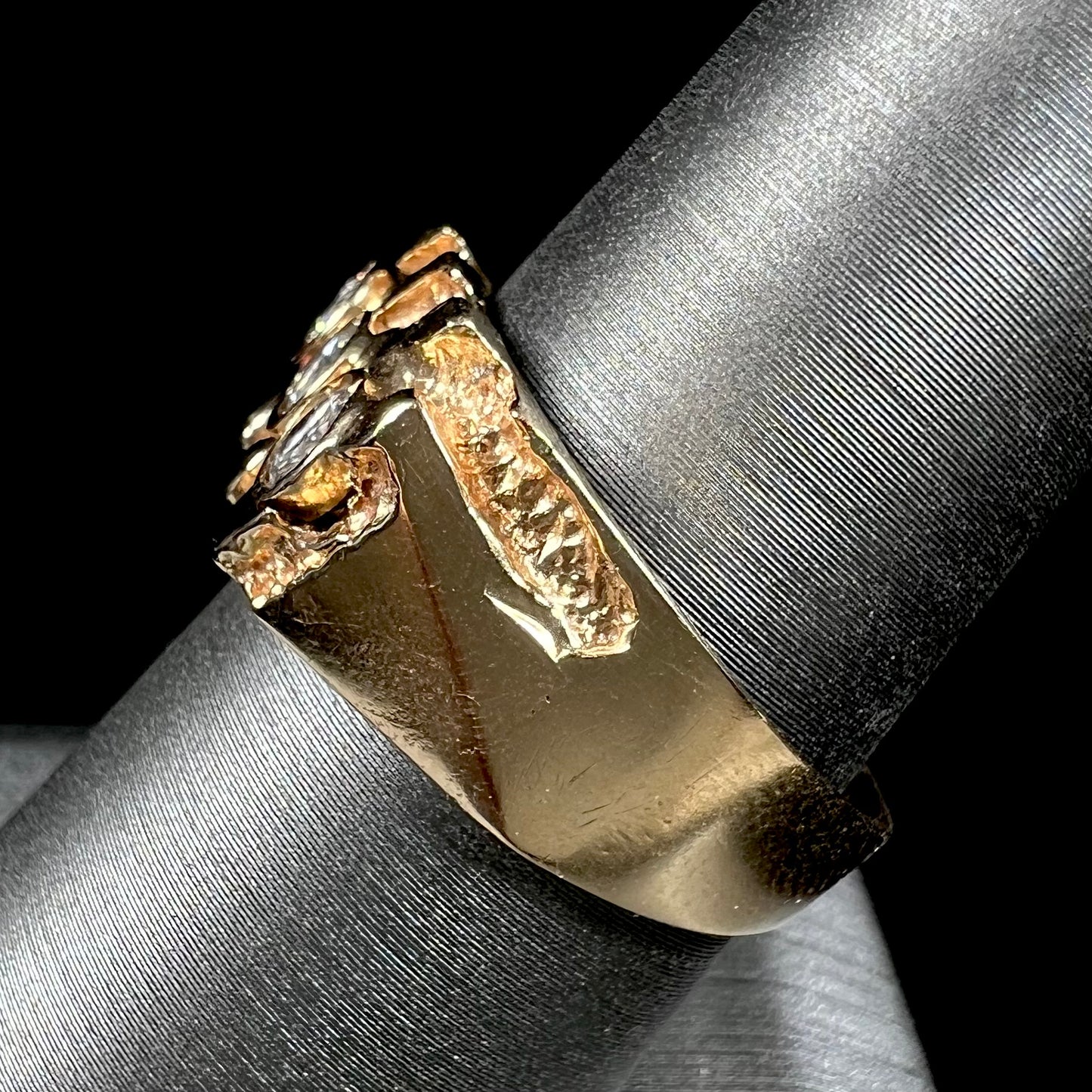 A men's yellow gold ring set with three round brilliant cut diamonds.  There are scratches along the shank.