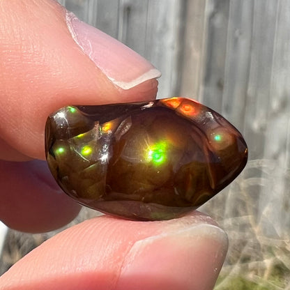 A loose fire agate stone.  The stone has a rainbow of metallic iridescence.