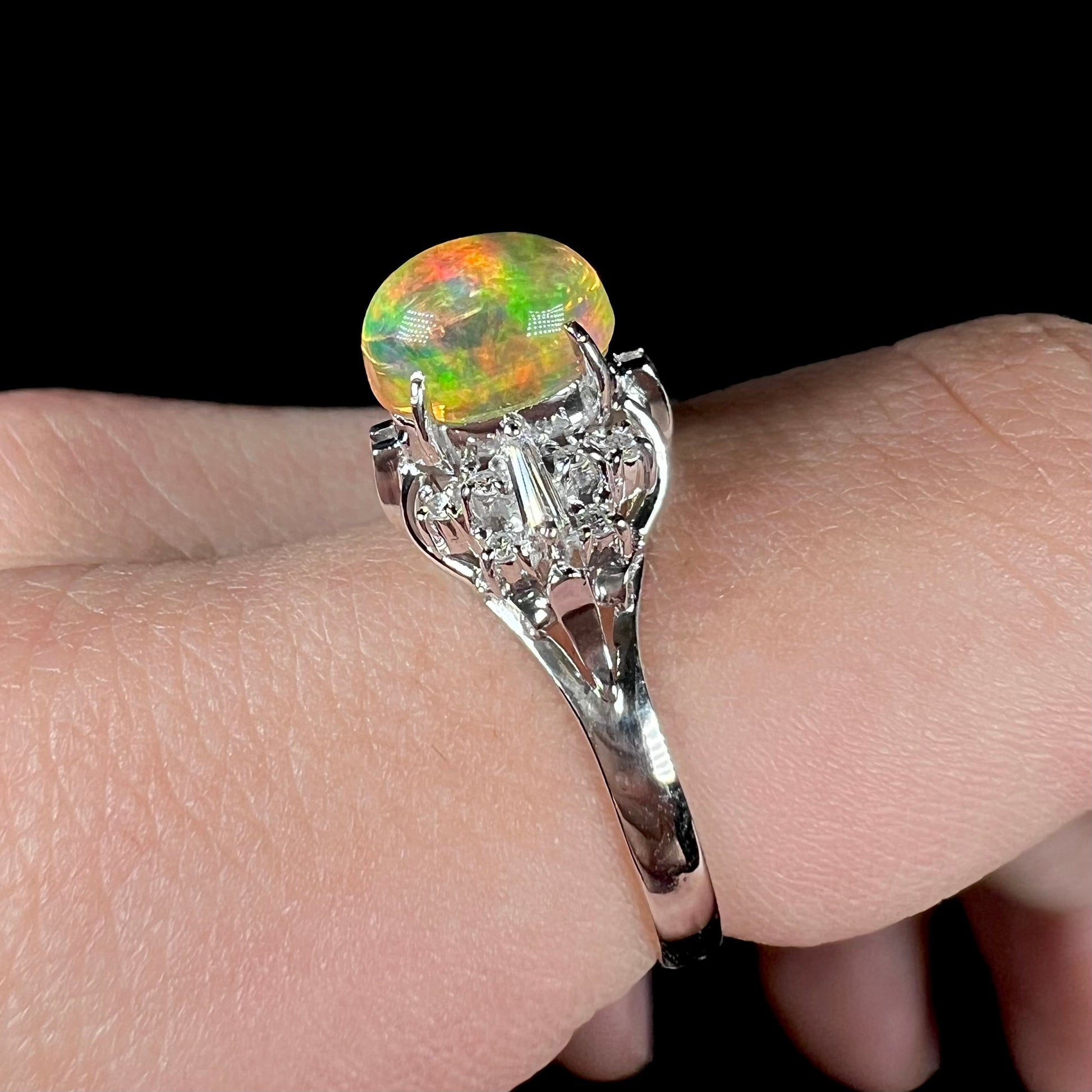 A platinum filigree ring mounted with a high-domed Mexican fire opal and baguette cut diamond accents.