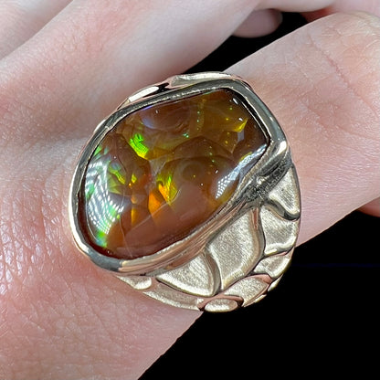 A men's heavy yellow gold ring mounted with a Mexican fire agate stone.  The shank of the ring is textured.