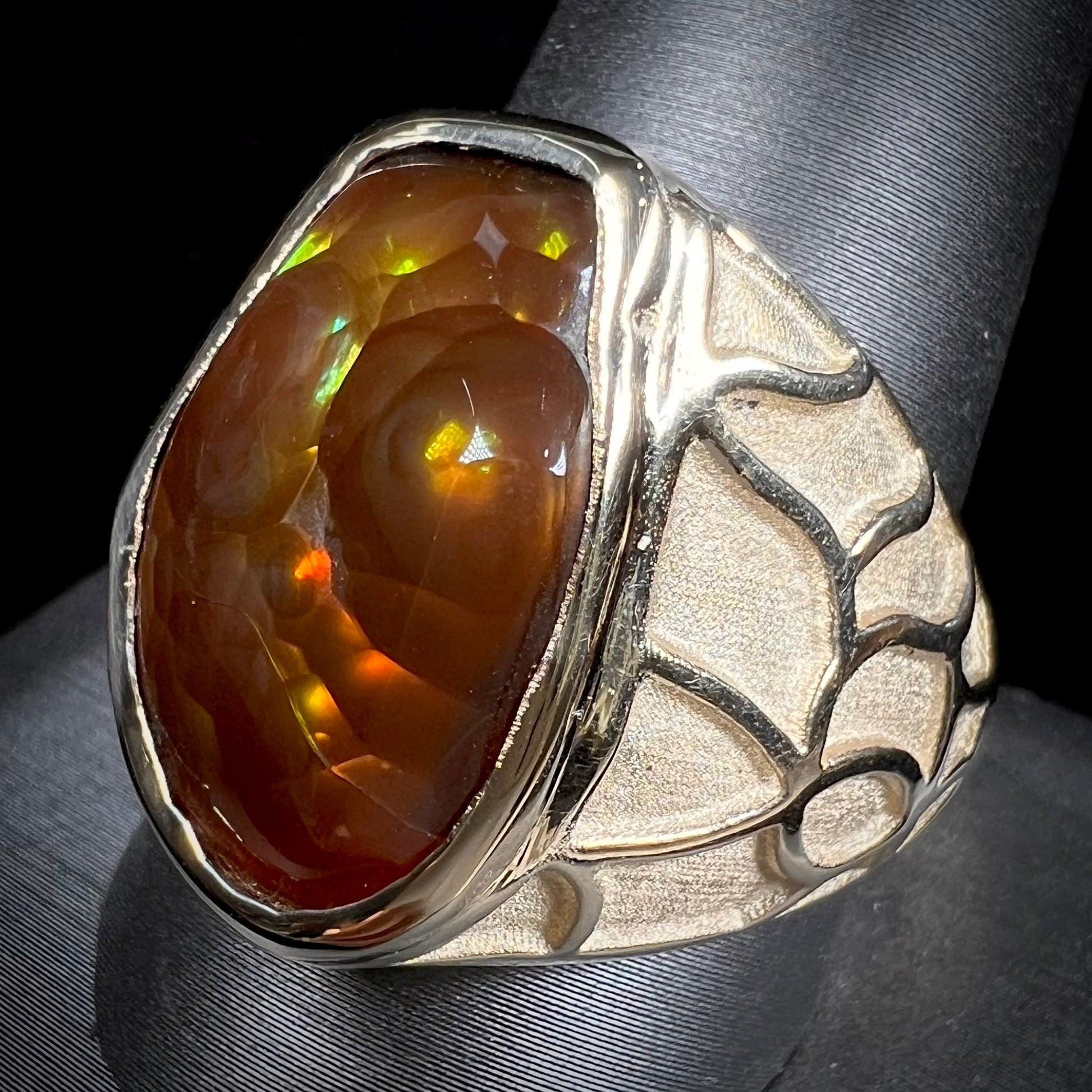 A men's heavy yellow gold ring mounted with a Mexican fire agate stone.  The shank of the ring is textured.