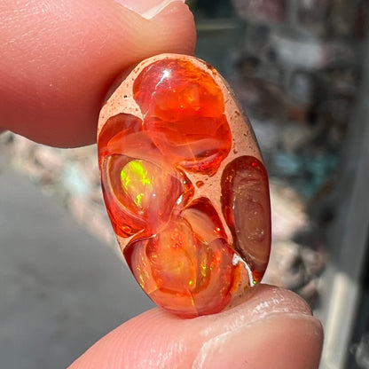 A loose Mexican matrix fire opal stone.  The opal is orange with green flashes.