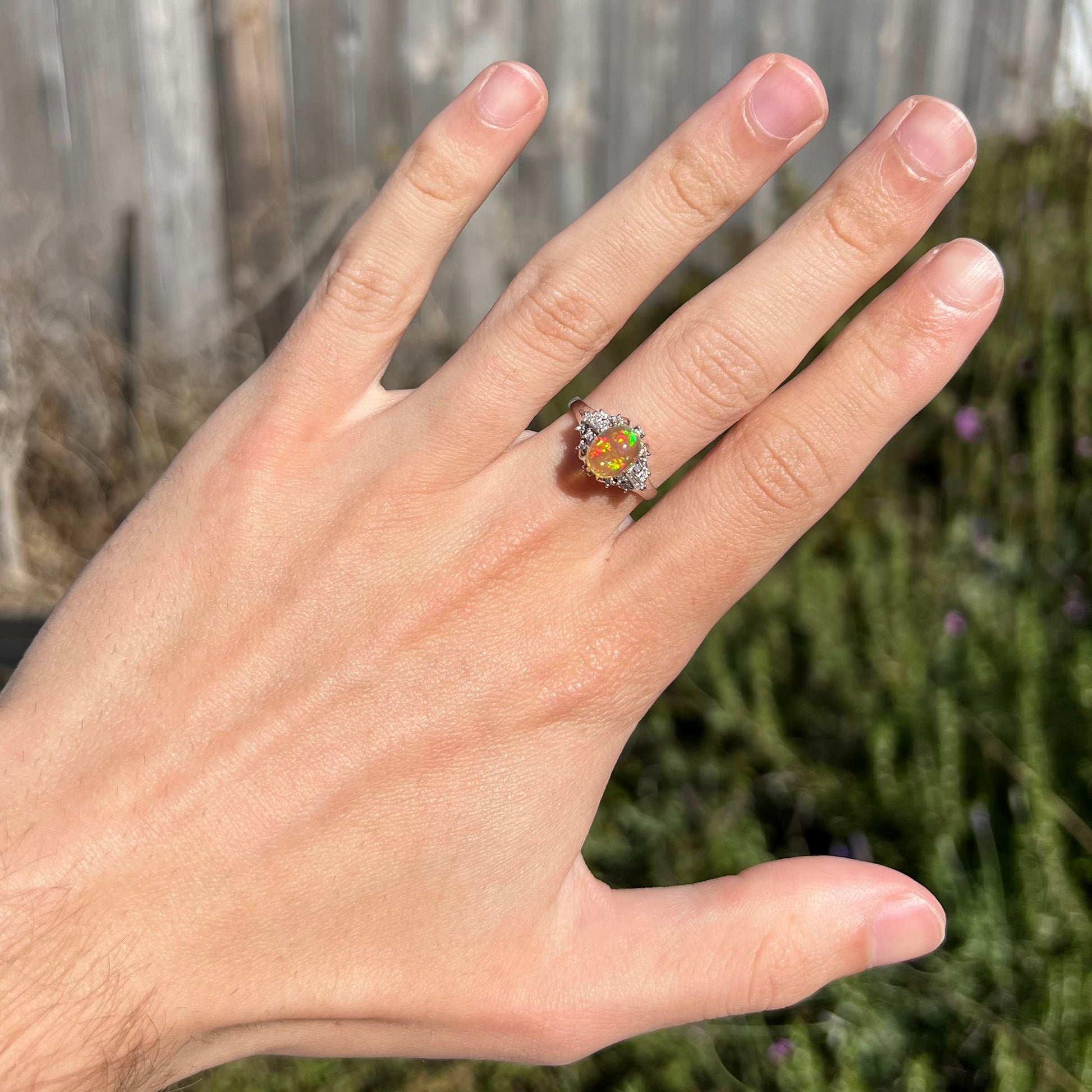 A platinum filigree ring mounted with a high-domed Mexican fire opal and baguette cut diamond accents.