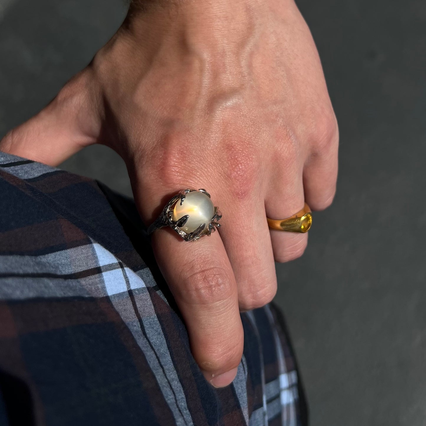 A ladies' organic style white gold moonstone ring.  The moonstone shows white adularescence on a creamy white body color.  Prongs resemble leaves holding the stone.