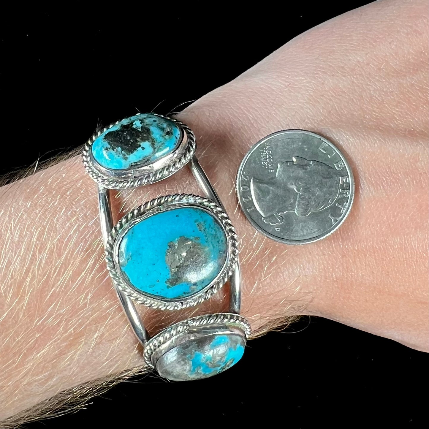 A ladies' three stone silver cuff bracelet accented with rope bezels and set with Morenci turquoise.