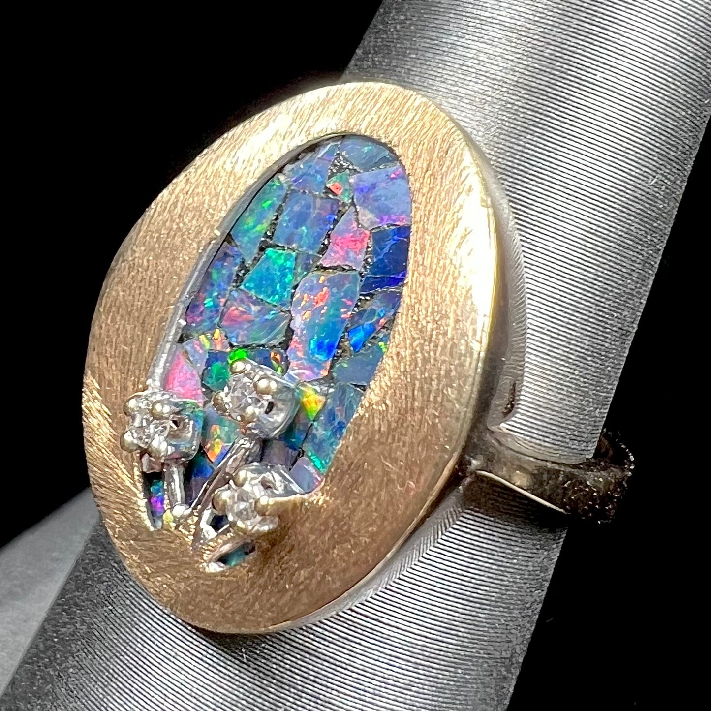 A vintage mosaic opal ring set with diamond accents in 10 karat yellow and white gold.