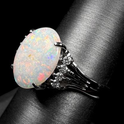 An Australian opal and diamond engagement ring in platinum.  The ring has filigree scrolling.