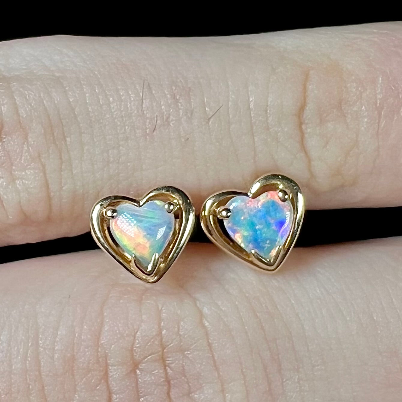 A pair of yellow gold stud earrings mounted with heart shaped natural crystal opals.