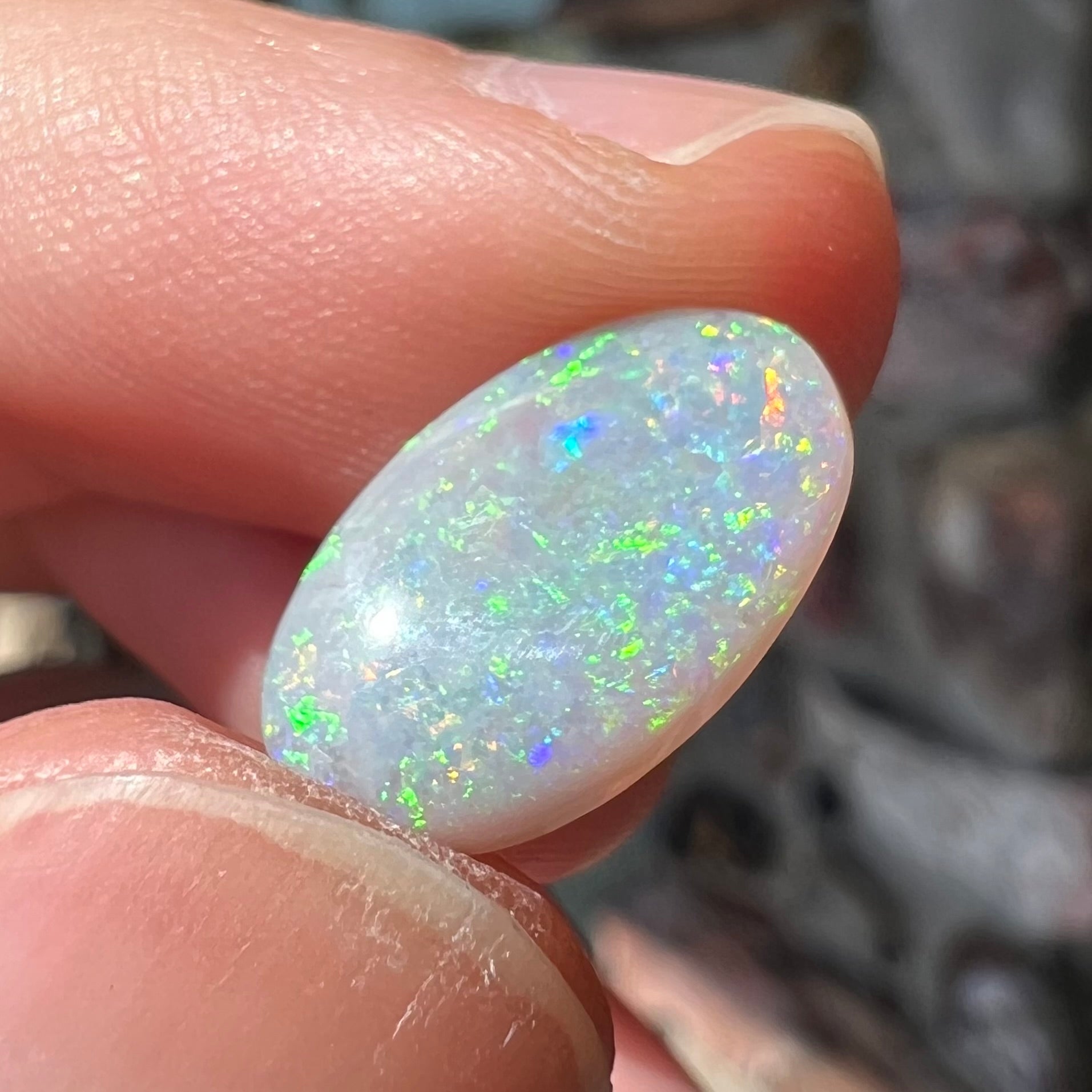 A semi-black, small flashfire opal stone from Mintabie, Australia.