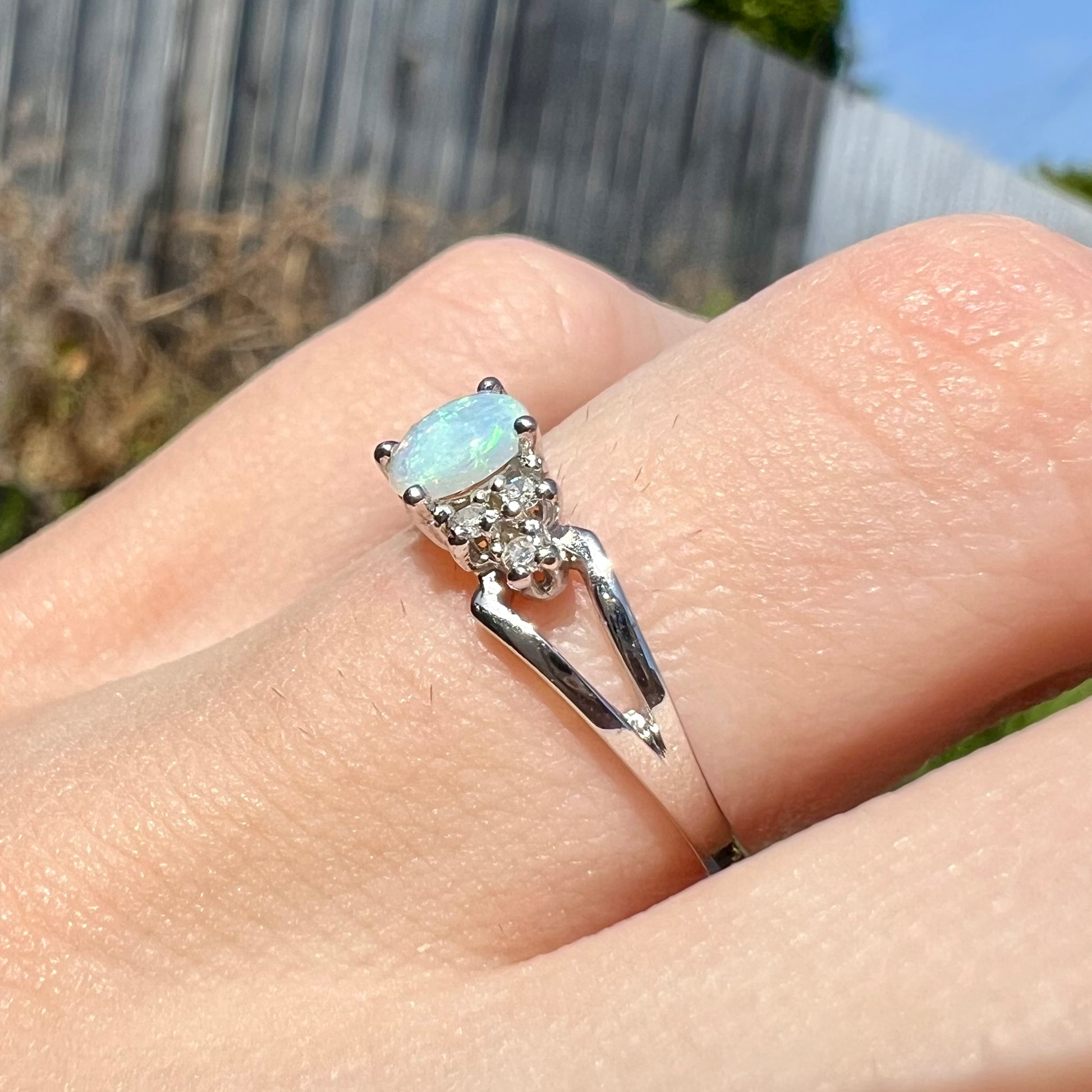 A ladies' white gold opal ring mounted with round diamond accents.