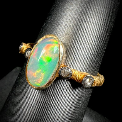 A yellow gold plated sterling silver ring mounted with an Ethiopian fire opal and rose cut diamond accents.