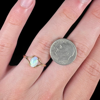 A ladies' simple opal solitaire ring.  The ring is yellow gold with a split shank.