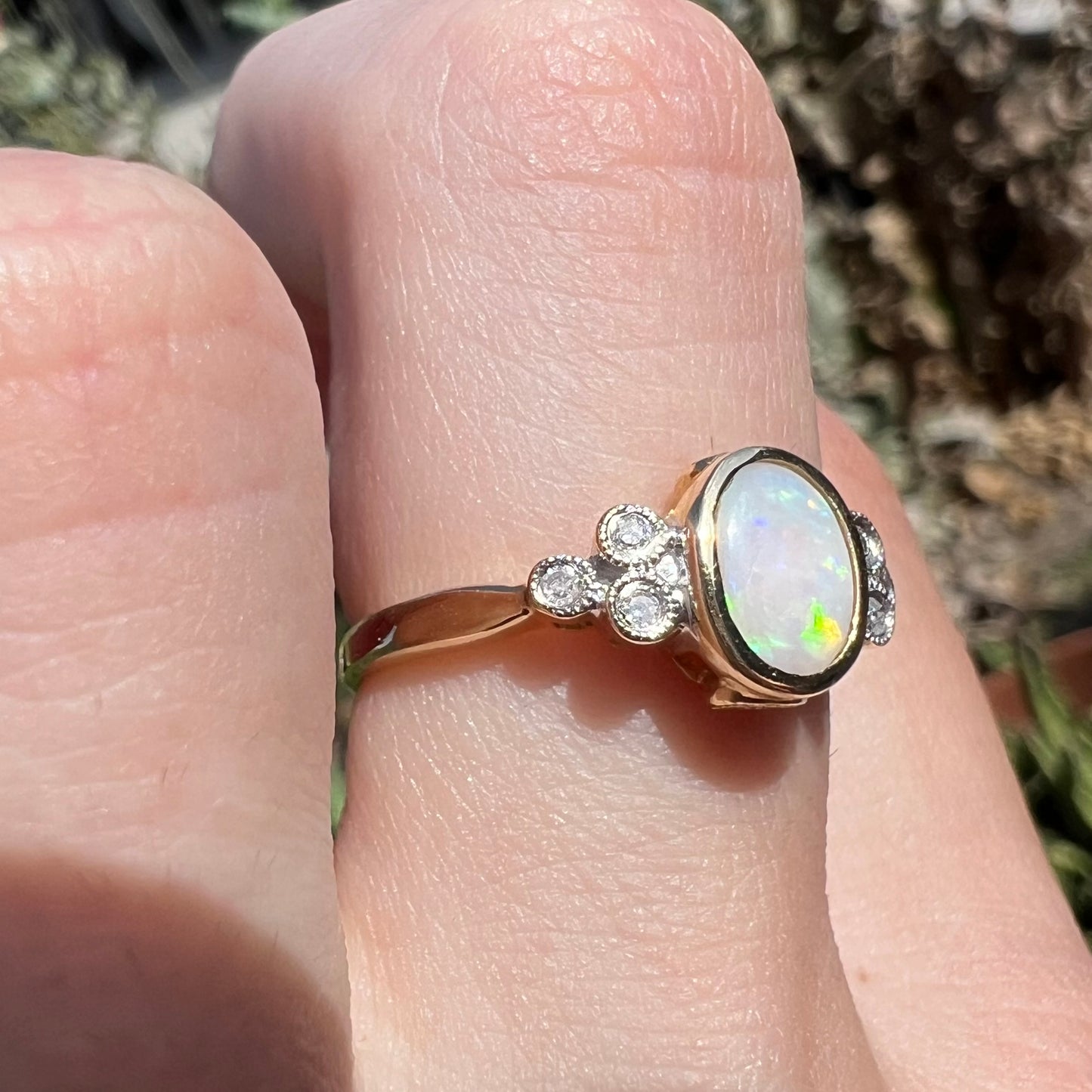 A ladies' yellow gold opal ring.  Three diamonds are set on each side of the opal.  Two rubies are set under the opal.