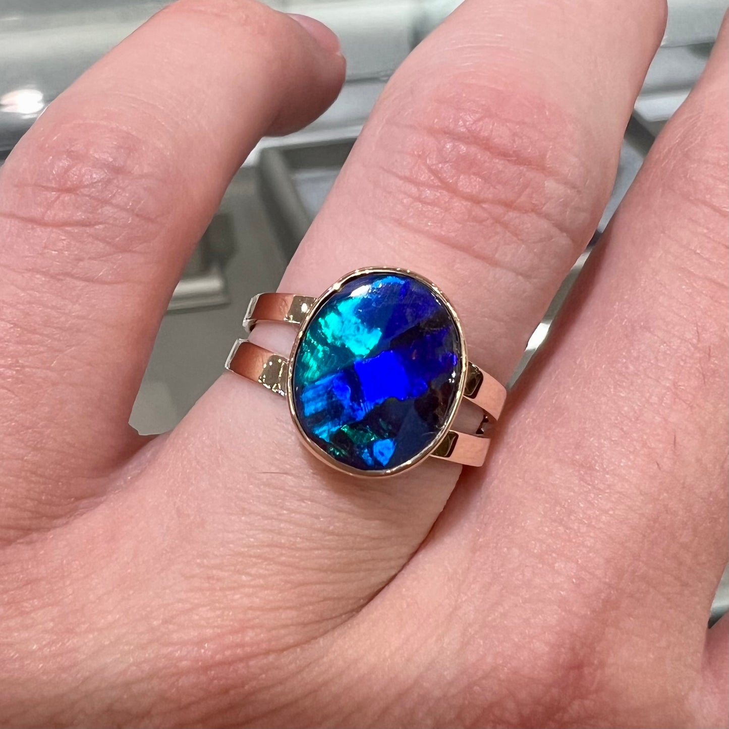 A ladies' split shank natural, Lightning Ridge, Australian black opal solitaire ring in yellow gold.