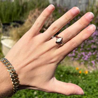 A marquise cut white opal ring.  The ring is accented with channel set reddish orange garnets.