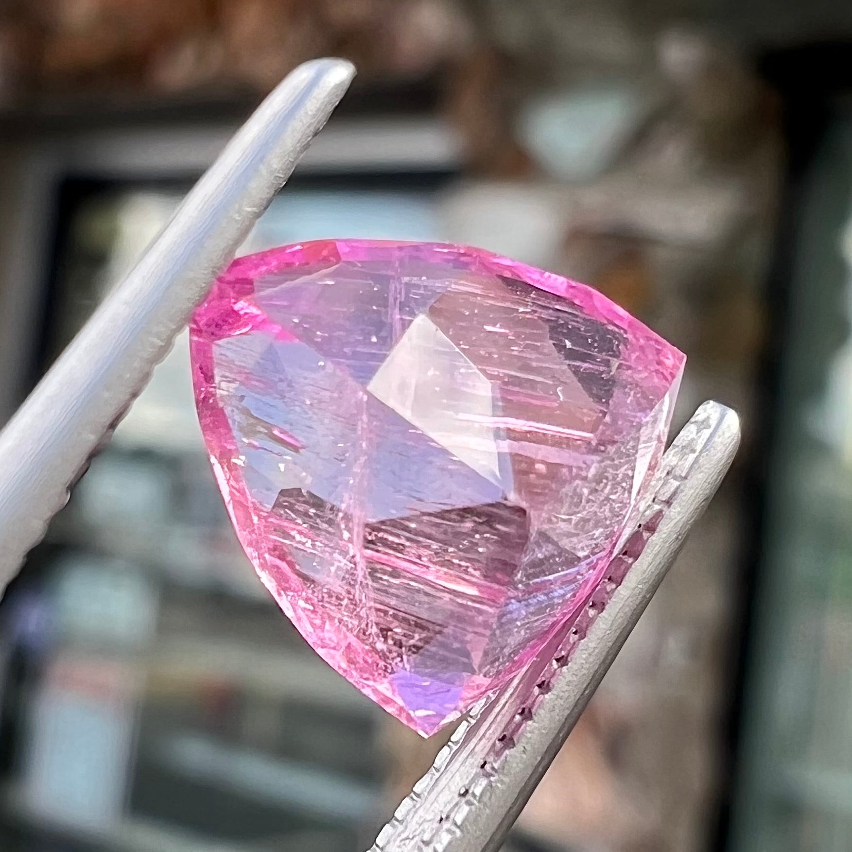 A loose, faceted trillion cut pink touramline gemstone.  The stone is a light bubblegum pink color.