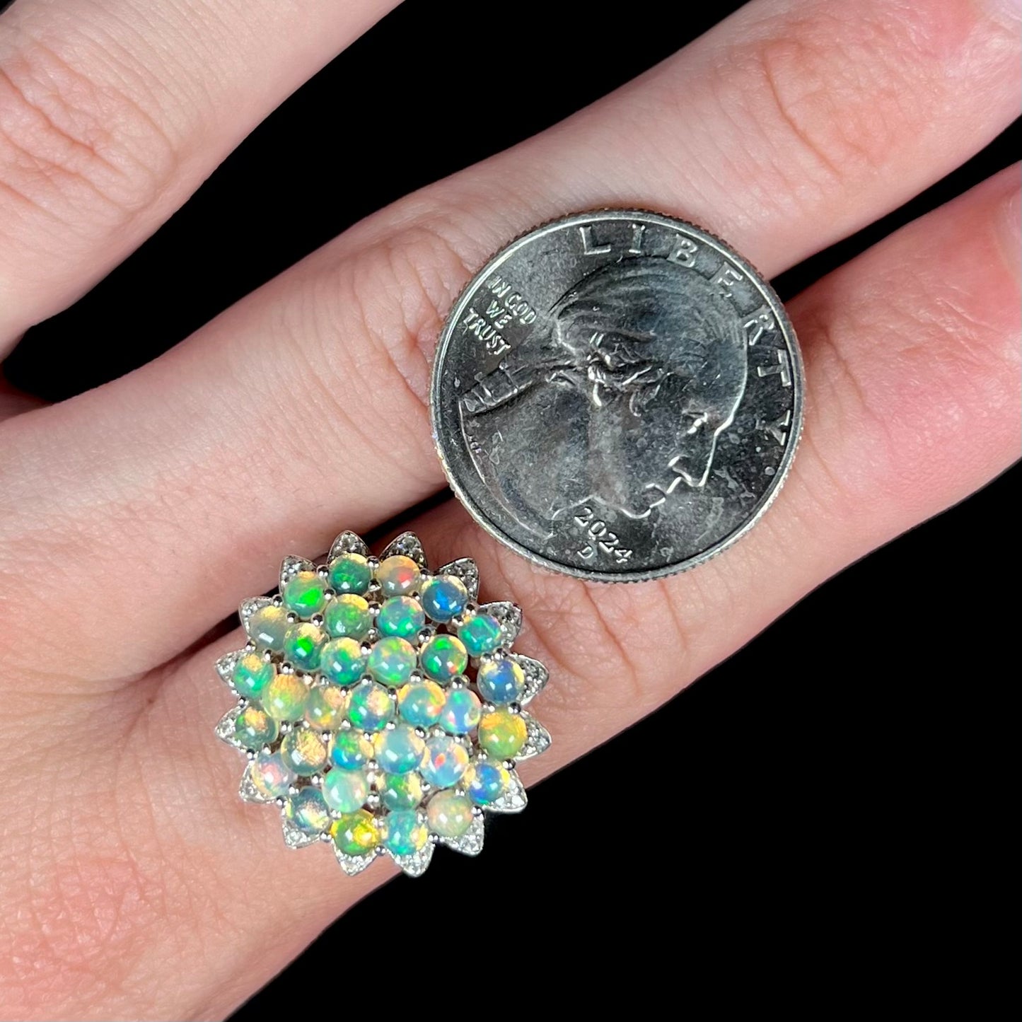 A sterling silver cluster flower ring mounted with 33 round Ethiopian fire opals.