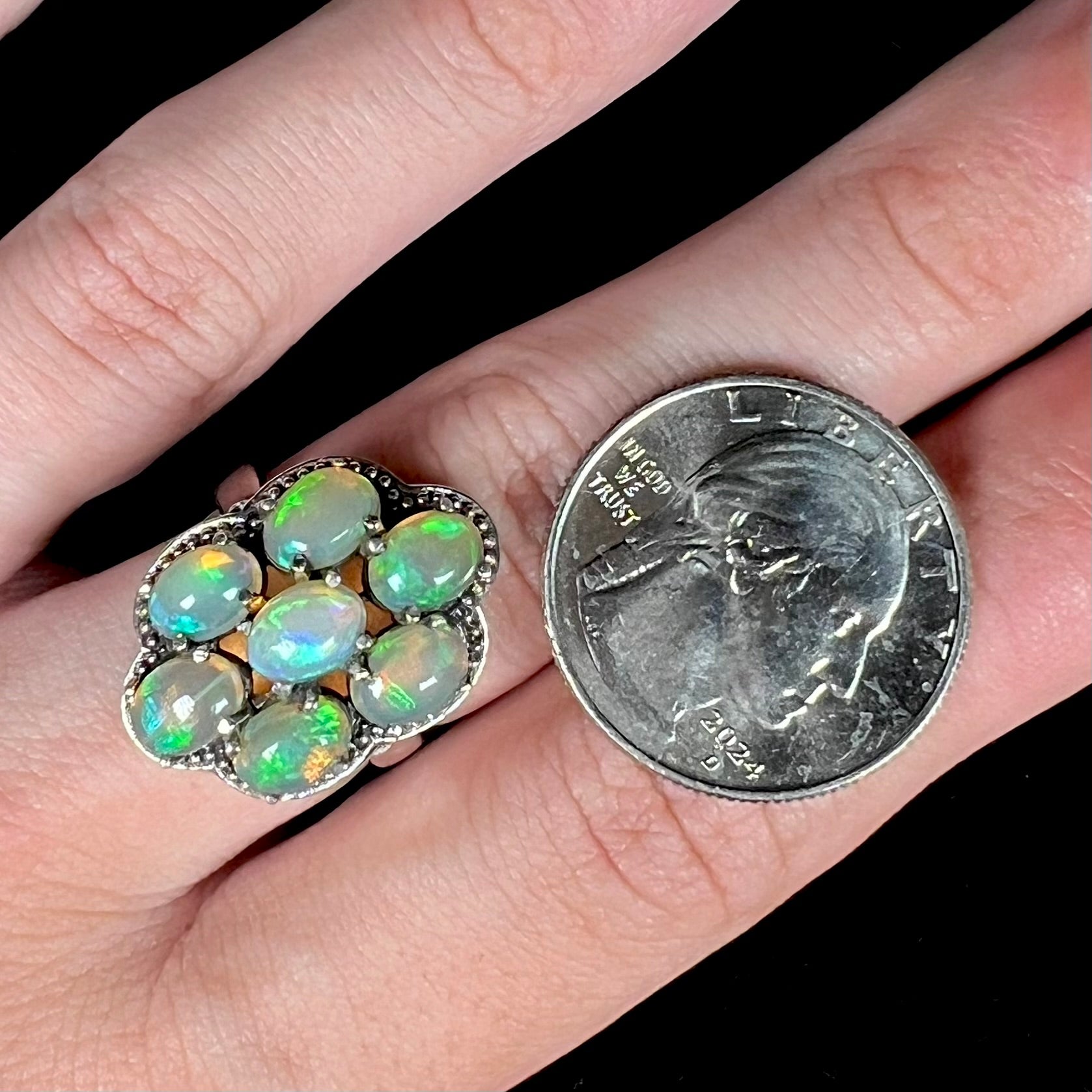 A sterling silver cluster ring prong-set with seven green Ethiopian fire opals.