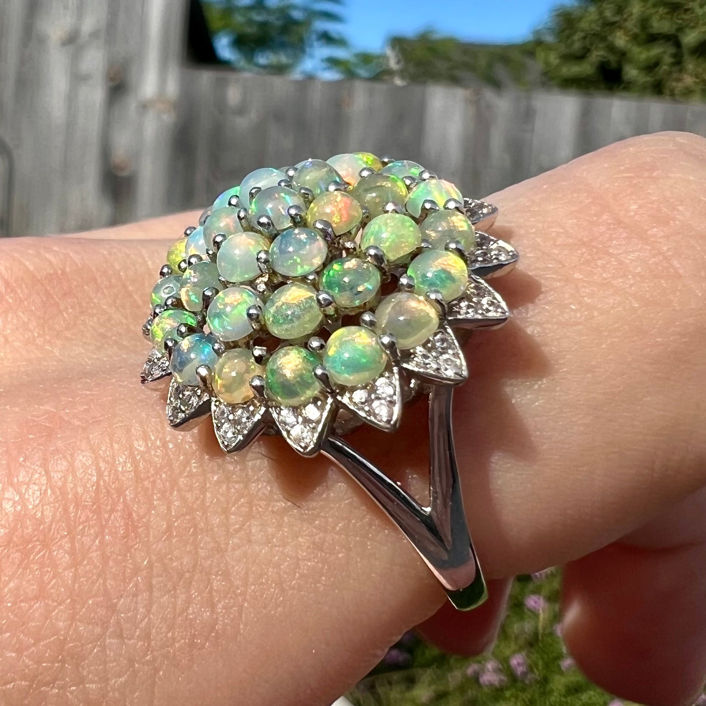 A sterling silver cluster flower ring mounted with 33 round Ethiopian fire opals.