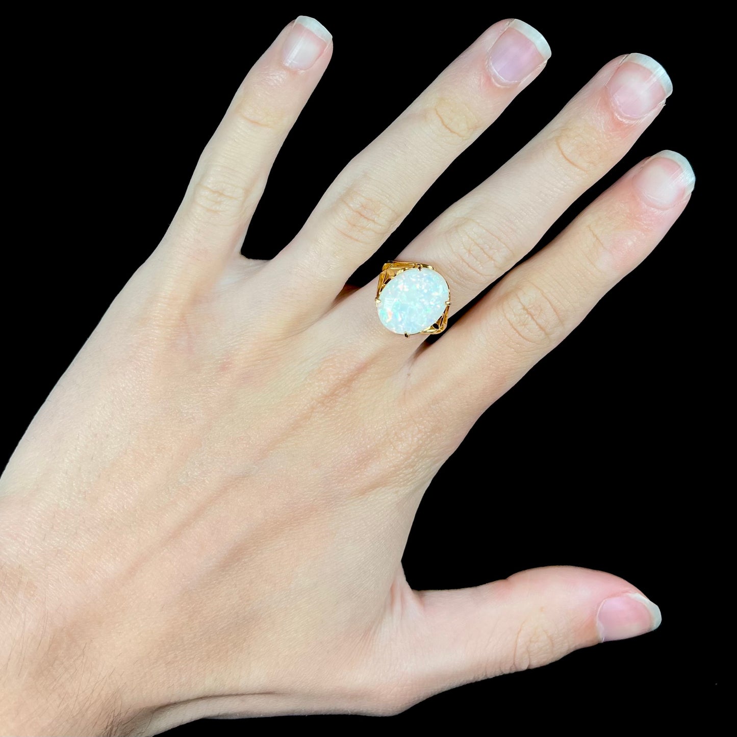 A yellow gold solitaire cocktail ring mounted with a natural white opal from Coober Pedy, Australia.