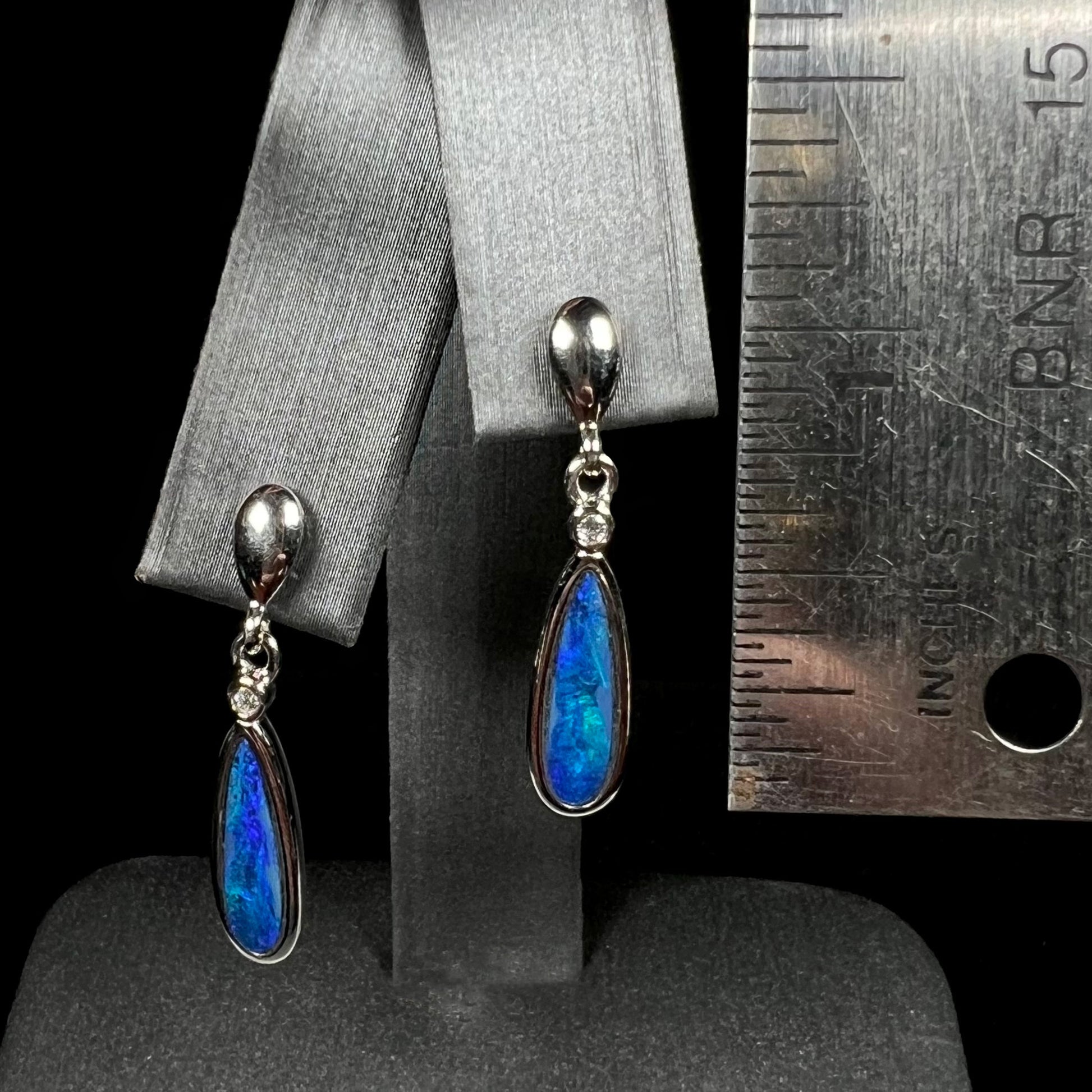 A pair of sterling silver dangle earrings mounted with pear shaped black opal doublets.