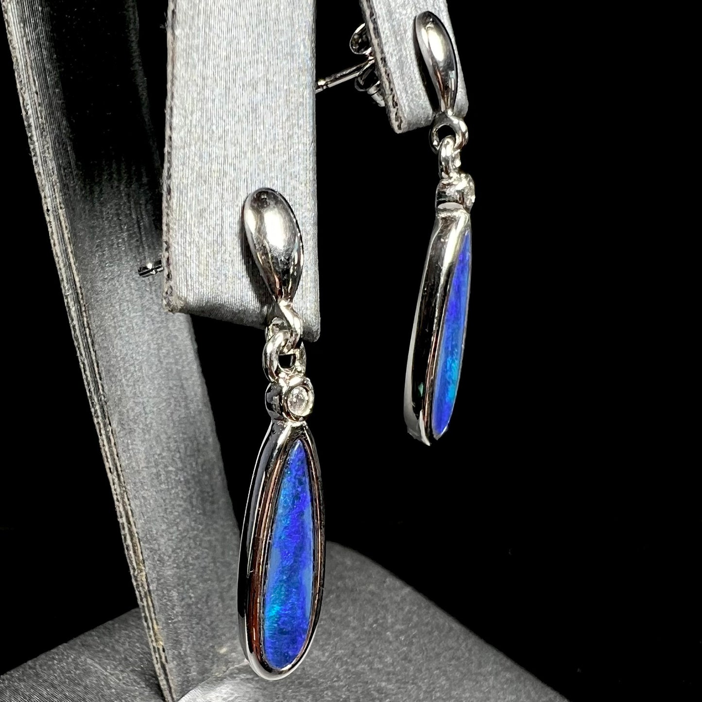 A pair of sterling silver dangle earrings mounted with pear shaped black opal doublets.