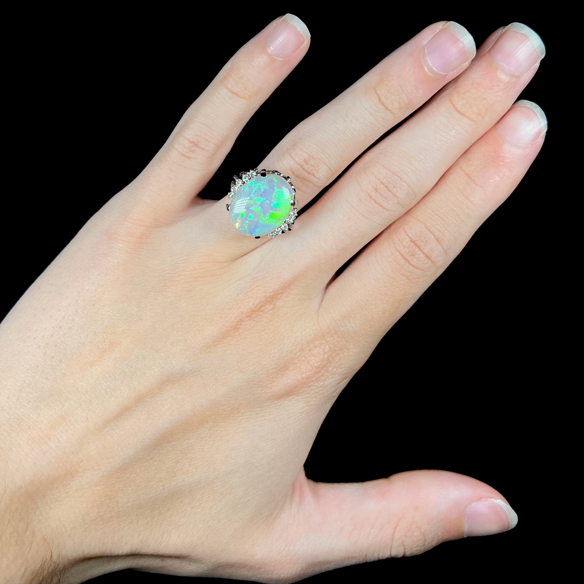 A platinum filigree ring set with a large, green-blue Mintabie crystal opal and diamonds.