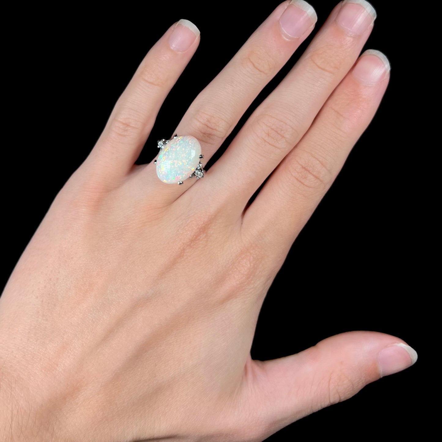 A platinum statement ring mounted with a 7.97ct Coober Pedy opal and marquise cut diamond accents.