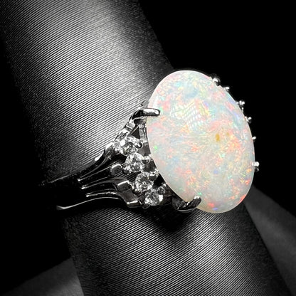 An Australian opal and diamond engagement ring in platinum.  The ring has filigree scrolling.