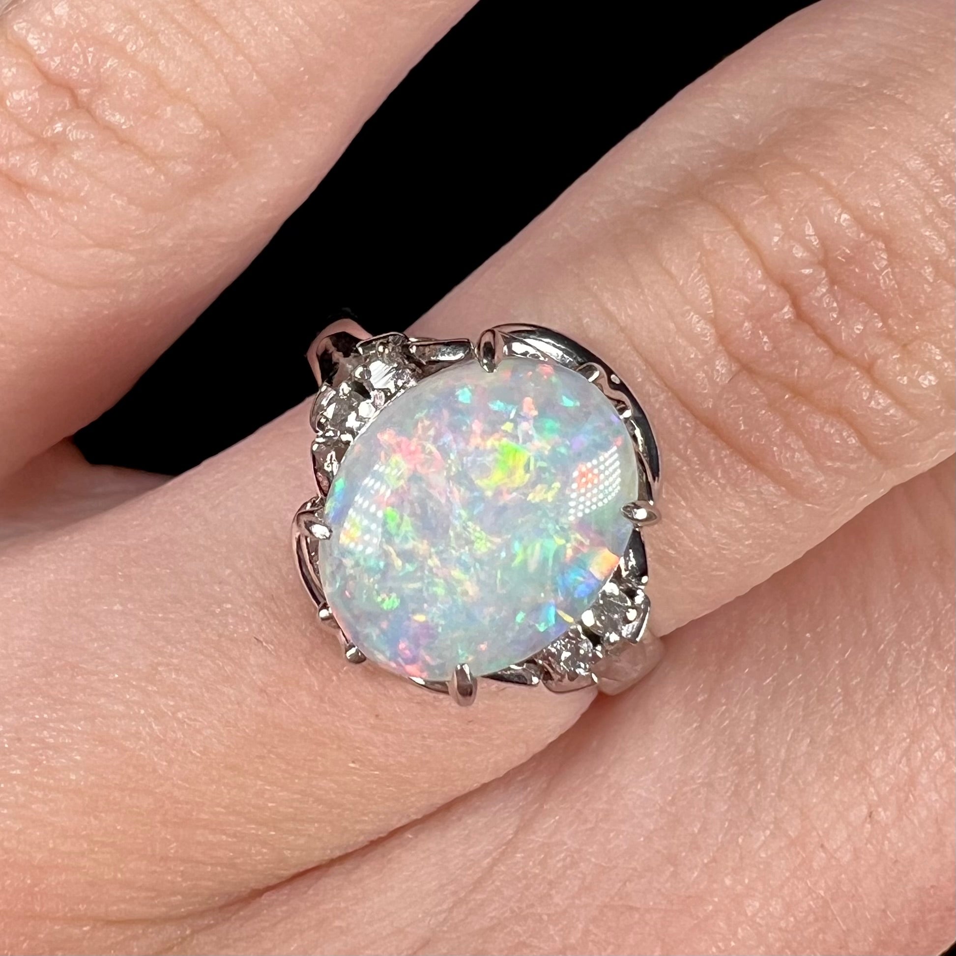 A platinum  and diamond ring prong-set with an Australian opal.  The opal has pink color play.