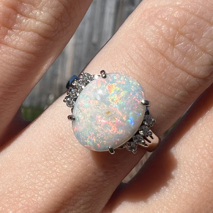 An Australian opal and diamond engagement ring in platinum.  The ring has filigree scrolling.