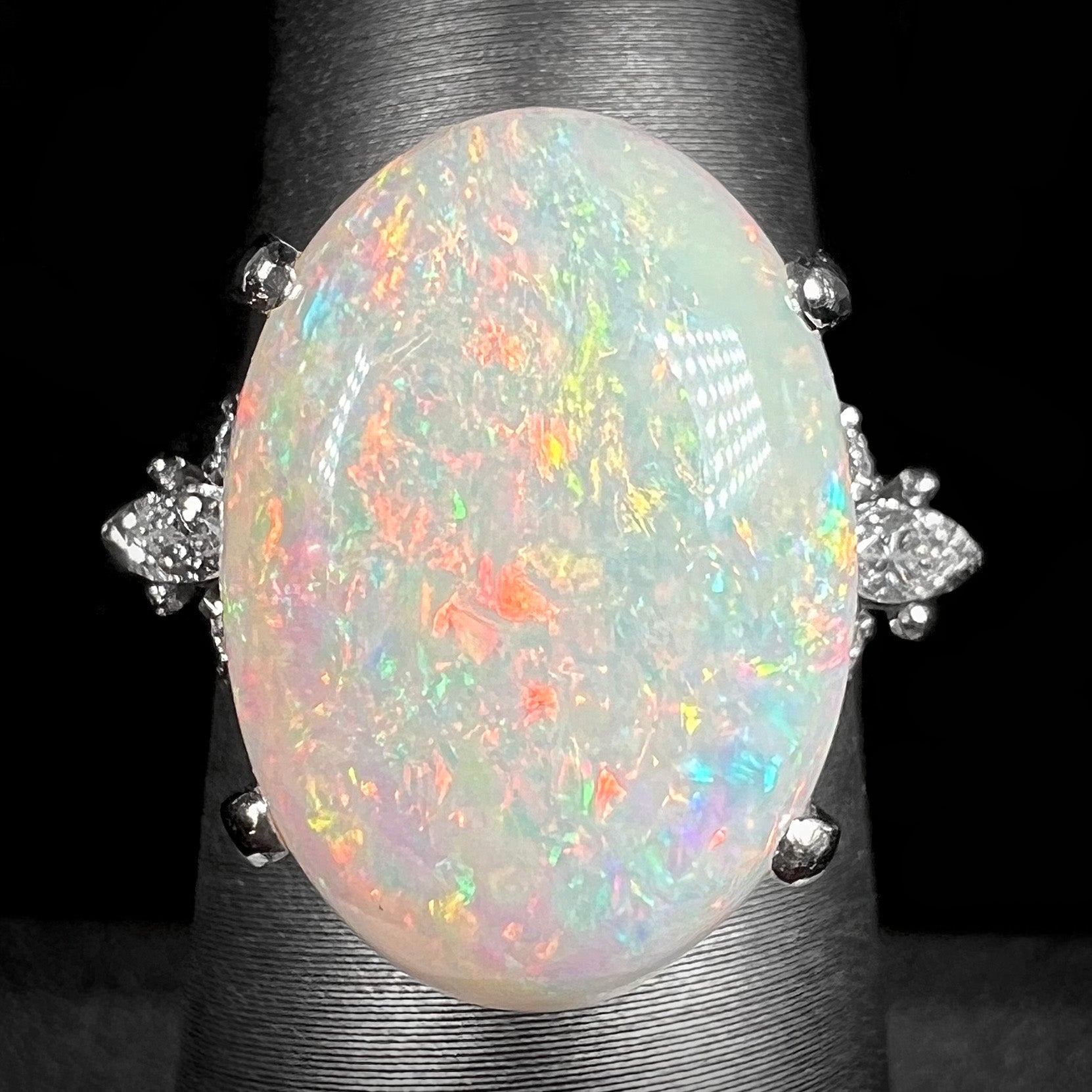 A platinum statement ring mounted with a 7.97ct Coober Pedy opal and marquise cut diamond accents.