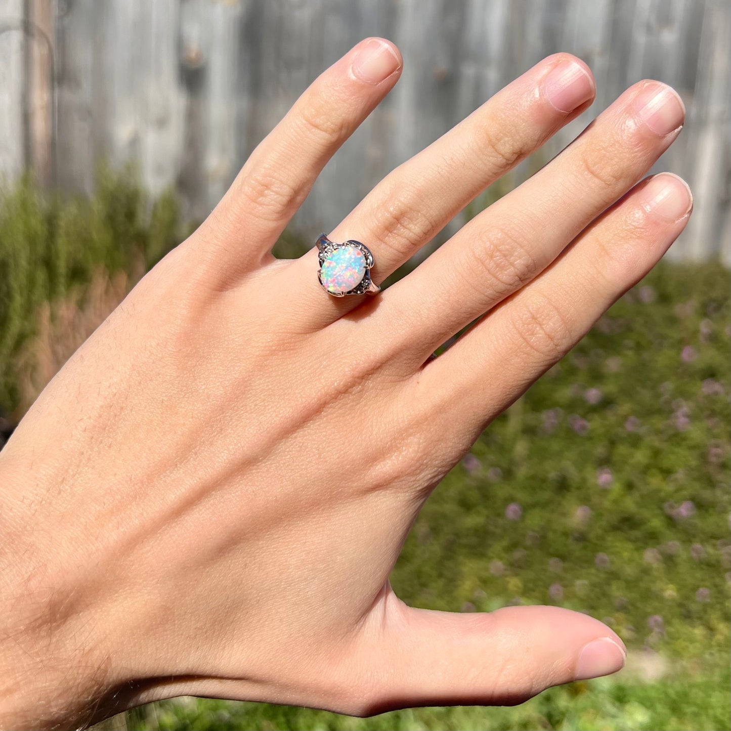 A platinum  and diamond ring prong-set with an Australian opal.  The opal has pink color play.