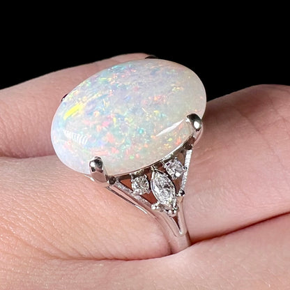 A platinum statement ring mounted with a 7.97ct Coober Pedy opal and marquise cut diamond accents.