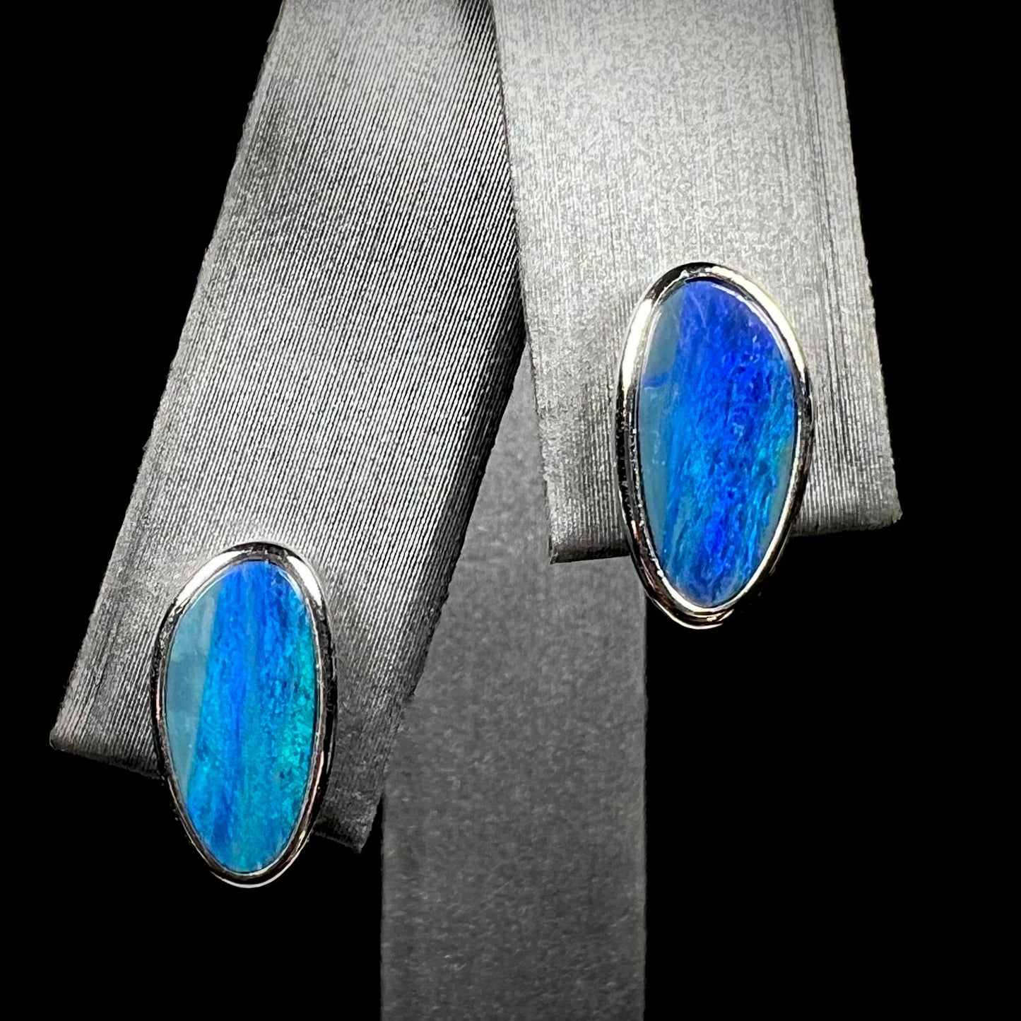 A pair of sterling silver opal doublet stud earrings.  The opals have a vivid blue color.