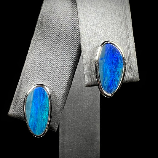 A pair of sterling silver opal doublet stud earrings.  The opals have a vivid blue color.