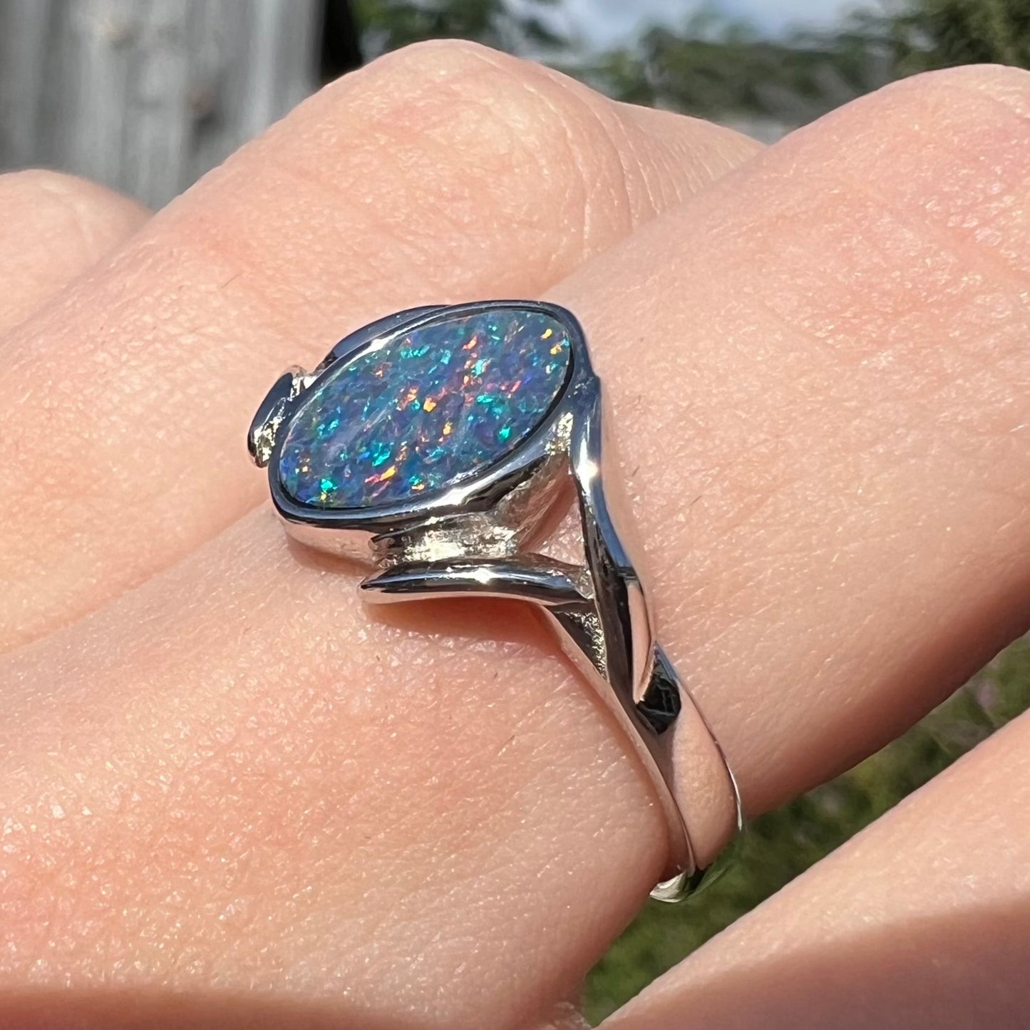 A silver leaf-style ring mounted with a multicolor black opal doublet.