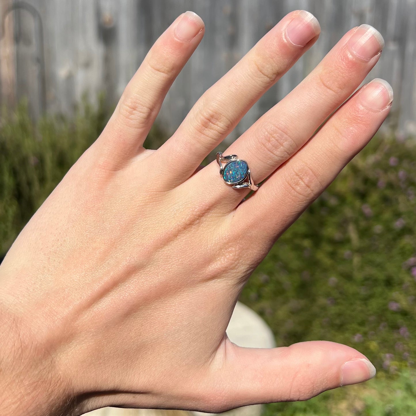 A silver leaf-style ring mounted with a multicolor black opal doublet.