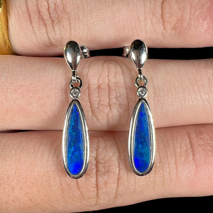 A pair of sterling silver dangle earrings mounted with pear shaped black opal doublets.