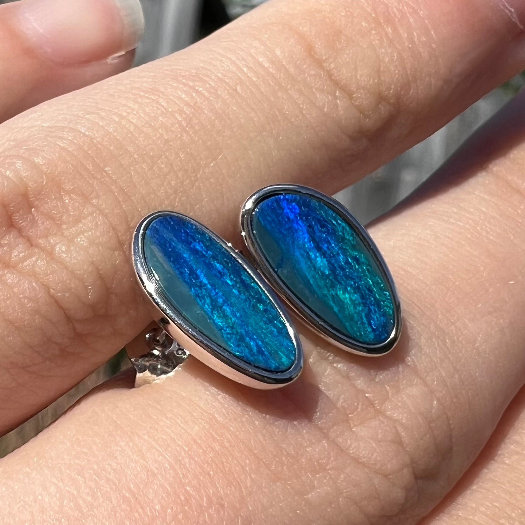 A pair of sterling silver opal doublet stud earrings.  The opals have a vivid blue color.