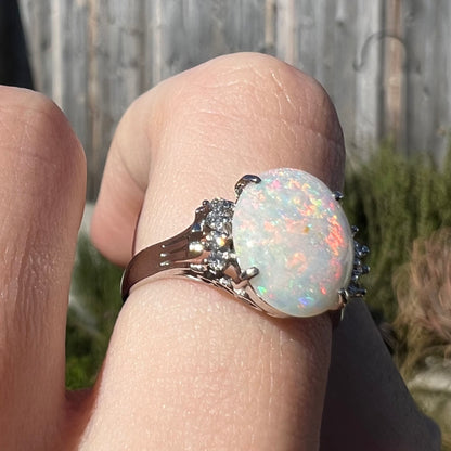 An Australian opal and diamond engagement ring in platinum.  The ring has filigree scrolling.