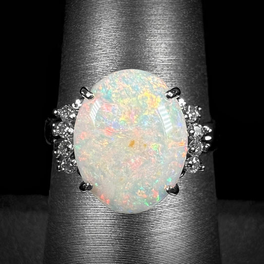 An Australian opal and diamond engagement ring in platinum.  The ring has filigree scrolling.