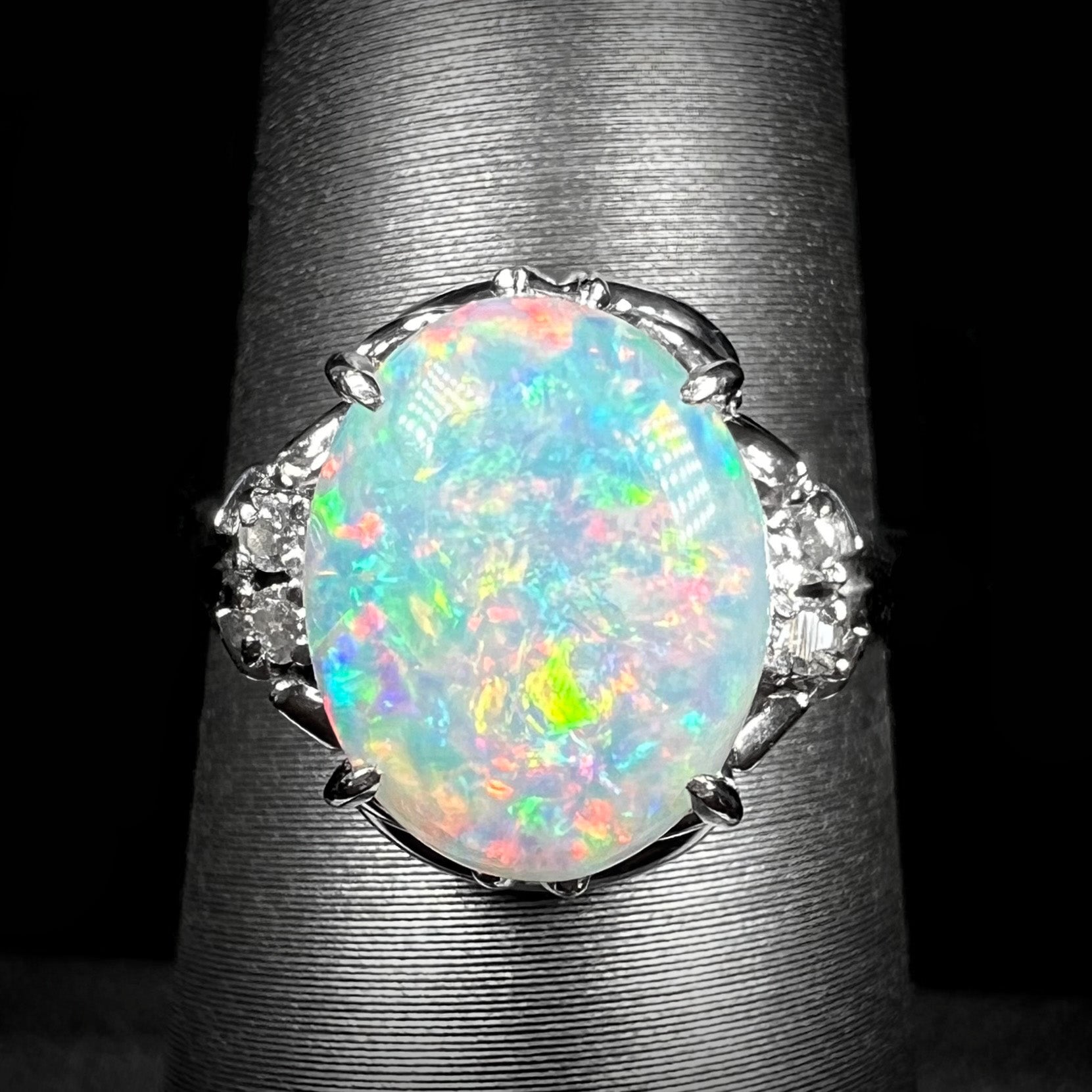 A platinum  and diamond ring prong-set with an Australian opal.  The opal has pink color play.