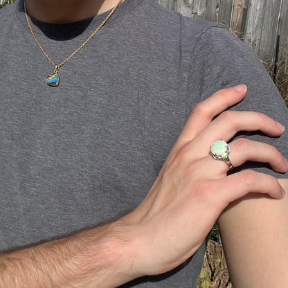 A round cut Australian opal and diamond engagment ring with platinum filigree.