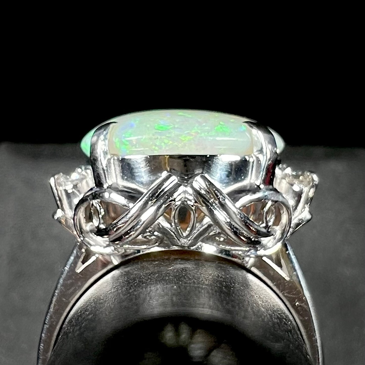 A round cut Australian opal and diamond engagment ring with platinum filigree.