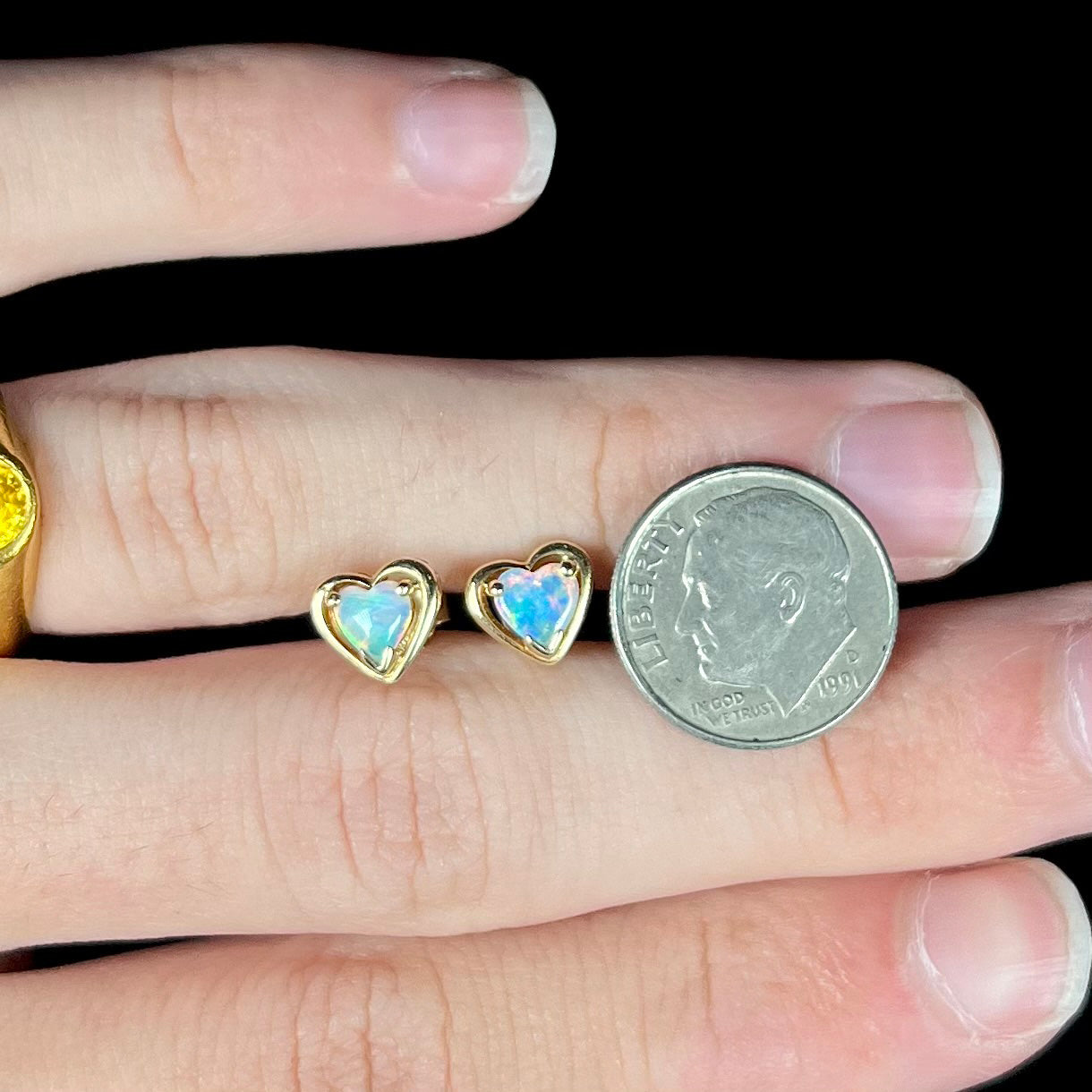 A pair of yellow gold stud earrings mounted with heart shaped natural crystal opals.